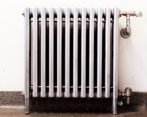 Closeup of an old radiator with a new thermostat